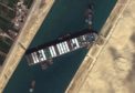 A satellite image made available by MAXAR Technologies shows tug boats positioned alongside the Ever Given in the Suez Canal on March 27.