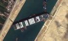 A satellite image made available by MAXAR Technologies shows tug boats positioned alongside the Ever Given in the Suez Canal on March 27.