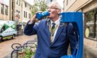 Fife Provost Jim Leishman tries out a top up tap in Dunfermline.
