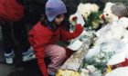 Abigail Longhurst lays flowers outside Dunblane Primary School.