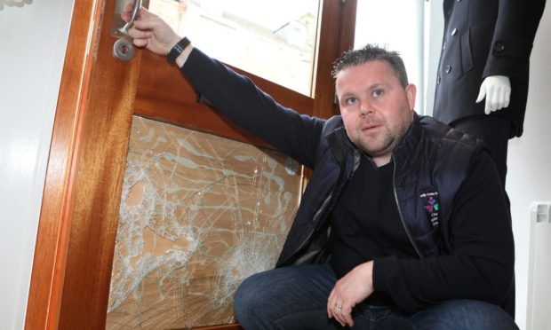 Evening telegraph/ Courier news CR0027163   G Jennings pics , Johnathan Booth surveys the damage to his shop " Millars" in Gray St Broughty Ferry after there was an attempted breakin during the night, thursday 18th march.