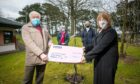 Kirriemuir Landward East community council chairman Ivan Laird presents the cheque to Lippen Care chairwoman Moira Nicoll, watched by Lippen Care manager Marion Hood and Lorna Bruce of KLECC.