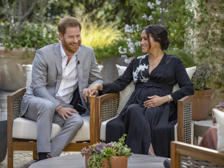 Photo show a relaxed and happy looking Prince Harry and Meghan Markle during their interview with Oprah Winfrey