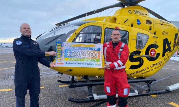 SCAA pilot Captain Pete Winn and lead paramedic Ewan Littlejohn with the latest funding award from People's Postcode Lottery.