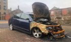 To go with story by James Simpson. A vehicle which was damaged in a blaze last year still sits within a car park. Picture shows; A damaged car.. Brown Street Dundee. James Simpson/DCT Media Date; 09/03/2021