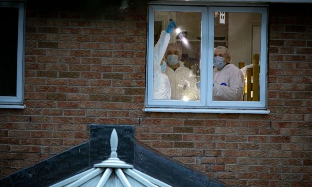 Forensics officers examining a bedroom in the Troon Avenue property on Saturday evening.