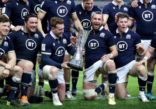 The Scots celebrate with the Auld Alliance trophy after their win in Paris.