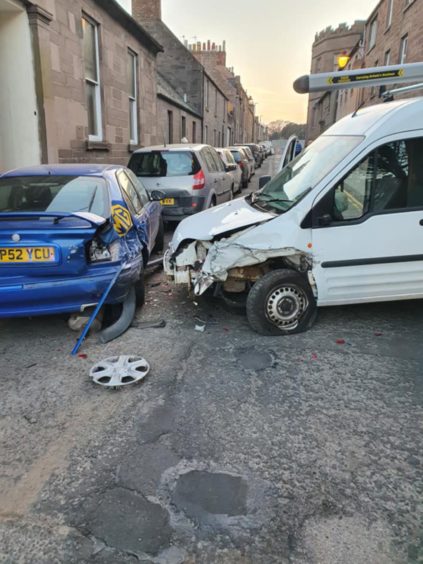 The damage caused to the blue MG car and the white van.
