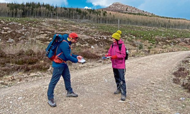 Hillgoers founder Garry Cormack shows Gayle how to navigate on a trip exploring Bennachie.