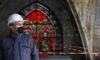 French President Emmanuel Macron stands by a stained glass window under the damaged vaults during a visit at the reconstruction site of the Notre-Dame de Paris cathedral, Thursday April 15, 2021. Two years after a fire tore through Paris' most famous cathedral and shocked the world, French President Emmanuel Macron on Thursday visited the building site that Notre Dame has become to show that French heritage has not been forgotten despite the coronavirus. (Ian Langsdon, Pool via AP)