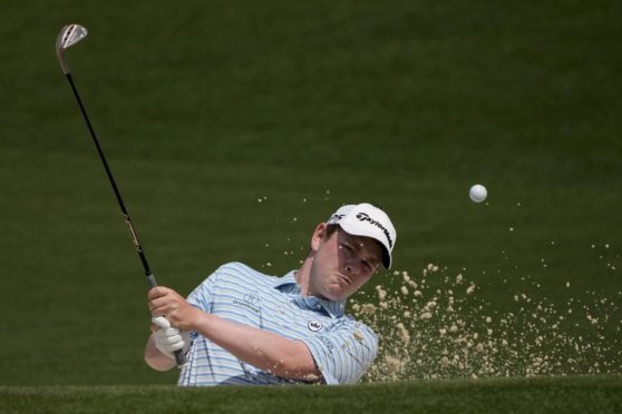 Robert MacIntyrehits out of a bunker on the second during his 74 at Augusta.