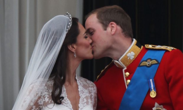 Their Royal Highnesses Prince William, Duke of Cambridge and Catherine, Duchess of Cambridge kiss on the balcony at Buckingham Palace following their marriage.