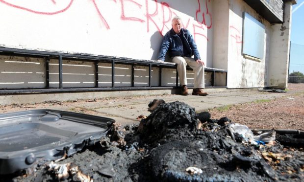 Craig Duncan with graffiti and fire damage at the Broughty Ferry pavilion.