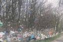 Plastic and rubbish blown into a wooded area in Dunfermline