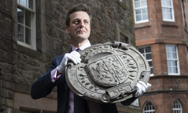 Head of House Sales Charlie Thomson holds one of four carved oak armorial panels from The Queen Regent's House, Blythe's Close, Edinburgh, which shows the impaled arms of King James V of Scotland and Mary Guise (the parents of Mary Queen of Scots). The armorial panels sold at auction for £17,750 at the Bonhams Edinburgh Dunrobin Attic Sale, an auction of hundreds of items found in the attics and cellars at Dunrobin Castle in Sutherland, the family seat of the 25th Earl of Sutherland. Picture date: Wednesday April 21, 2021. PA Photo. See PA story SALE Castle. Photo credit should read: Jane Barlow/PA Wire