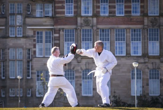 Scottish Liberal Democrat Leader Willie Rennie (right) takes part in a karate lesson with Robert Steggles at The Meadows, Edinburgh, during campaigning for the Scottish Parliamentary election. Picture date: Friday April 23, 2021. PA Photo. See PA story SCOTLAND Election. Photo credit should read: Jane Barlow/PA Wire