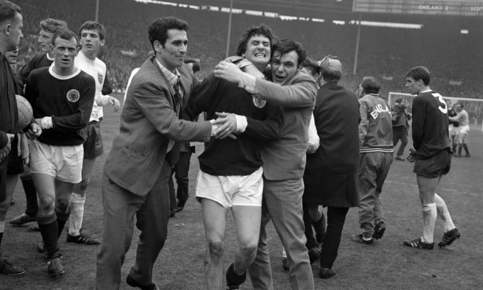 Jim Baxter was hugged by fans after Scotland's 3-2 win at Wembley in 1967.
