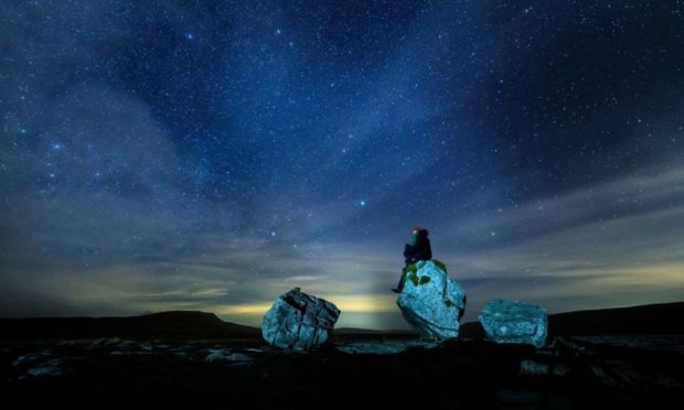 EDITORIAL USE ONLY
A walker looks up into the night sky above Twistleton Scar in The Yorkshire Dales National Park - the largest dark sky reserve in the UK - ahead of Dark Sky Week, starting on Monday. Issue date: Monday April 5, 2021. PA Photo. The Yorkshire Dales National Park was officially designated a Dark Sky Reserve by the International Dark Sky Association in November 2020. With large areas of unpolluted night sky, it makes it possible to see thousands of stars, the Milky Way, meteors and even the Northern Lights. Photo credit should read: Danny Lawson/PA Wire