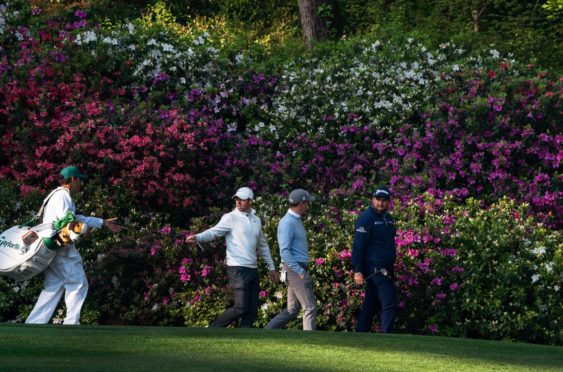 Justin Thomas and Rory McIlroy in practice with azalea backdrop at Augusta.