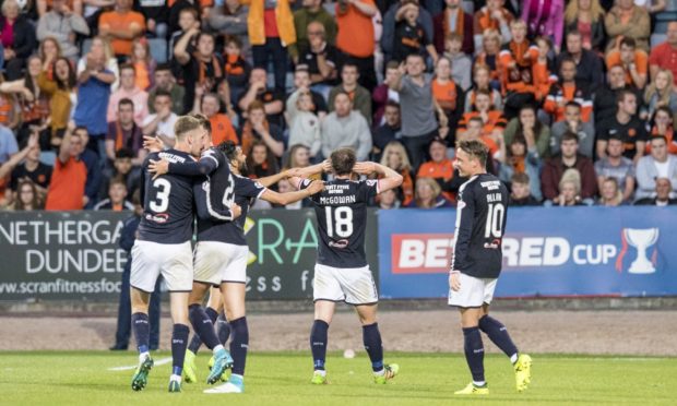 Paul McGowan celebrates in front of Dundee United fans.