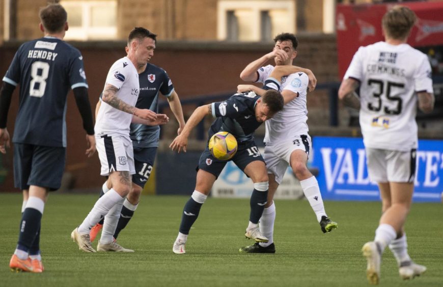 Surrounded by team-mates, Shaun Byrne battles with Raith's Lewis Vaughan during Dundee's play-off semi-final win in 2021.