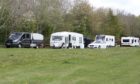 The caravans and vehicles parked up at the site.