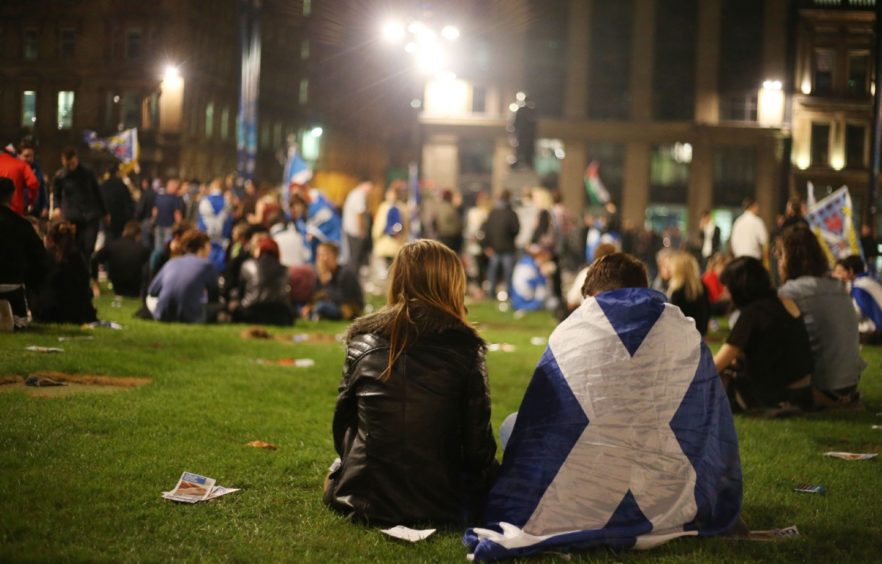 photo shows groups of independence supporters sitting on the grass in George Square, Glasgow, on the night of the 2014 referendum.