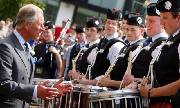 The Prince of Wales chats with members of the National Youth Pipe Band outside the National Piping Centre in Glasgow in 2009.