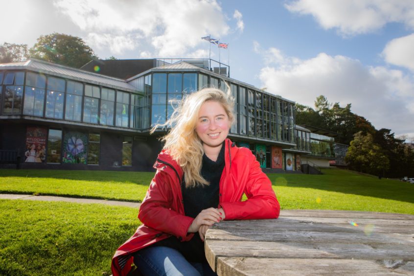 Elizaberh Newman seated at bench outside Pitlochry Festival Theatre