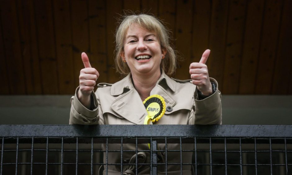 Shona Robison wearing an SNP rosette and giving the thumbs up sign