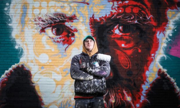 Street artist Michael Corr with his Michael Marra portrait in Aimer Square. Image: Mhairi Edwards/DC Thomson