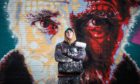 Michael Corr, a mural artist with his Michael Marra portrait in Aimer Square