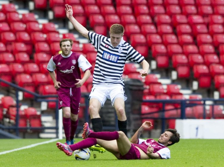 Shaun Rooney being tackled by Arbroath's Dylan Carreiro.