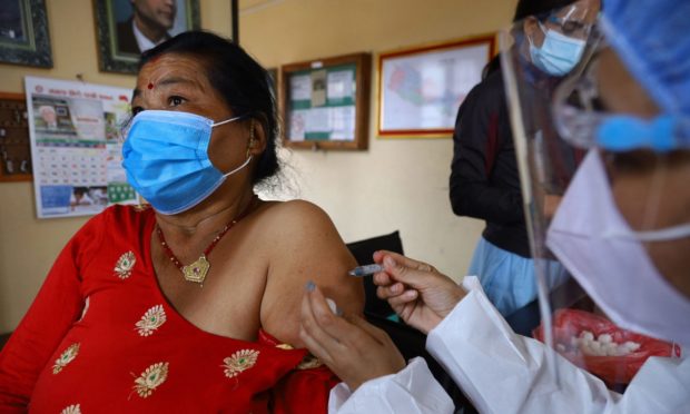 A women receiving her first dose of Vero Cell coronavirus vaccine at a vaccination centre in Kathmandu, Nepal.