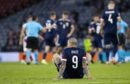 Scotland striker Lyndon Dykes sits dejected on the Hampden turf after the defeat to Croatia.