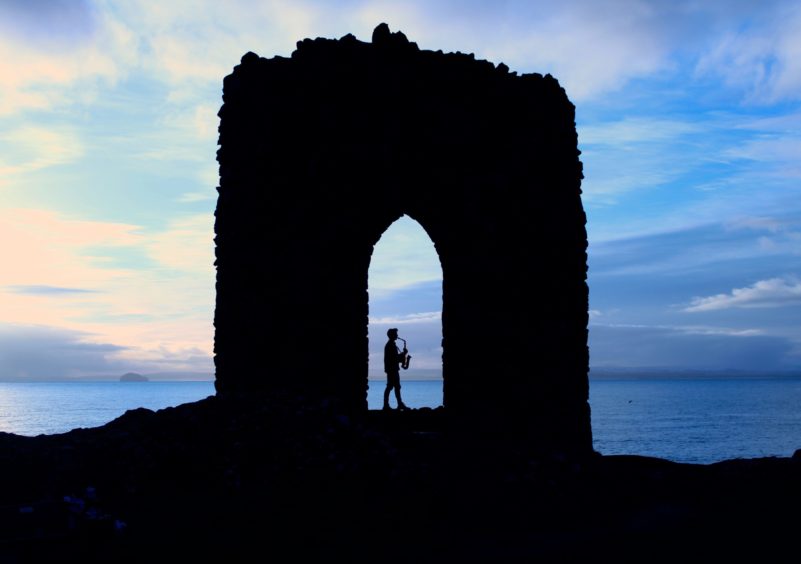 David Behrens playing the saxophone at Lady's Tower near Elie.