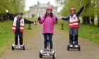 Gayle joins a Segway tour Haddo Country Park run by Wheelie Fun. The picture shows Gayle flanked by company owners Claire and Merv Christie in front of Haddo House.