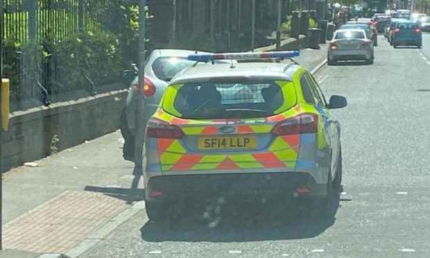 Police on Pitkerro Road, where the 'abandoned' vehicle was found.