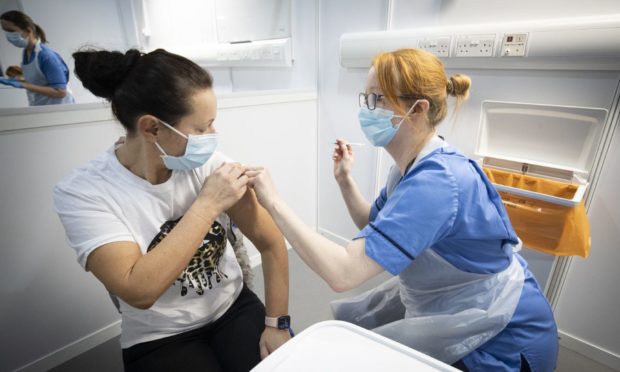 A woman receives a coronavirus vaccine.