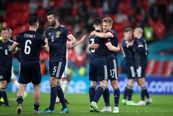 Scotland players embrace at the close of the game. Picture by PA.
