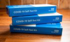 Three packs of covid home test kits