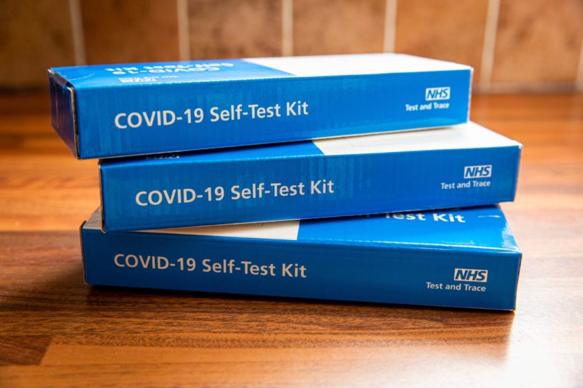 Three packs of covid home test kits