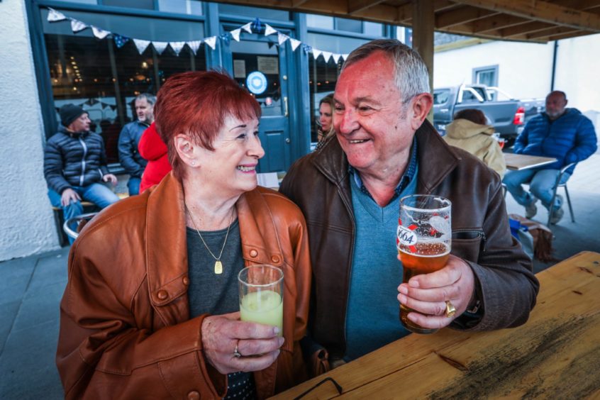 A man and woman enjoying drinks in a bar