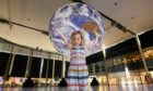 EDITORIAL USE ONLY
Amelie, aged 5, in front of the art installation entitled Gaia by Luke Jerram, as it goes on display at centre:mk as part of IF: Milton Keynes International Festival. Picture date: Friday July 9, 2021. PA Photo. Gaia measures 7m in diameter and features highly detailed NASA imagery of the Earths surface. It is one of 3 pieces to go on display at the shopping centre, which will also feature Arrivals + Departures by Yara + Davina and world premiere Breathing Room by Anna Berry. The IF: Milton Keynes International Festival 2021, of which centre:mk is the headline sponsor, runs in July from Saturday 10th to Friday 30th. Photo credit should read: Jonathan Hordle/PA Wire