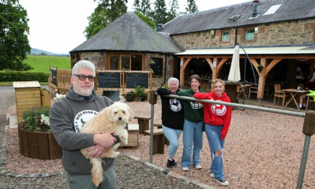 Gareth and Anne Finn, with daughter Orla, second from right, and staff member Niamh Henderson, with Bear the dog.