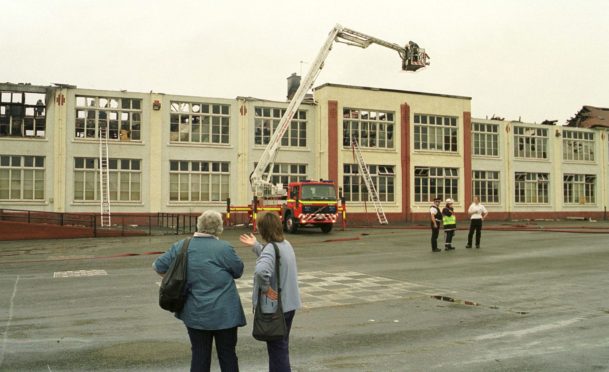 The aftermath of the blaze at King's Road Primary as locals look on at the damaged building.