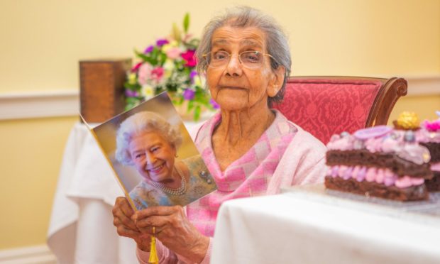 Daphne Shah holding 100th birthday telegram from Queen
