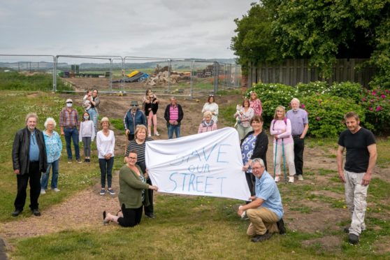 Residents gather to protest over the through road proposal.