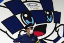 A masked security guard in front of Tokyo 2020 Olympics mascot Miraitowa.