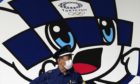 A masked security guard in front of Tokyo 2020 Olympics mascot Miraitowa.